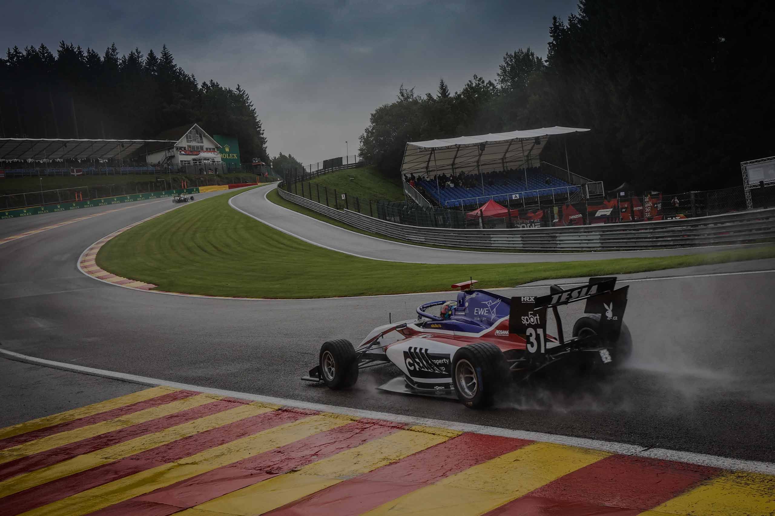 Single-seater racing car cornering on a wet track