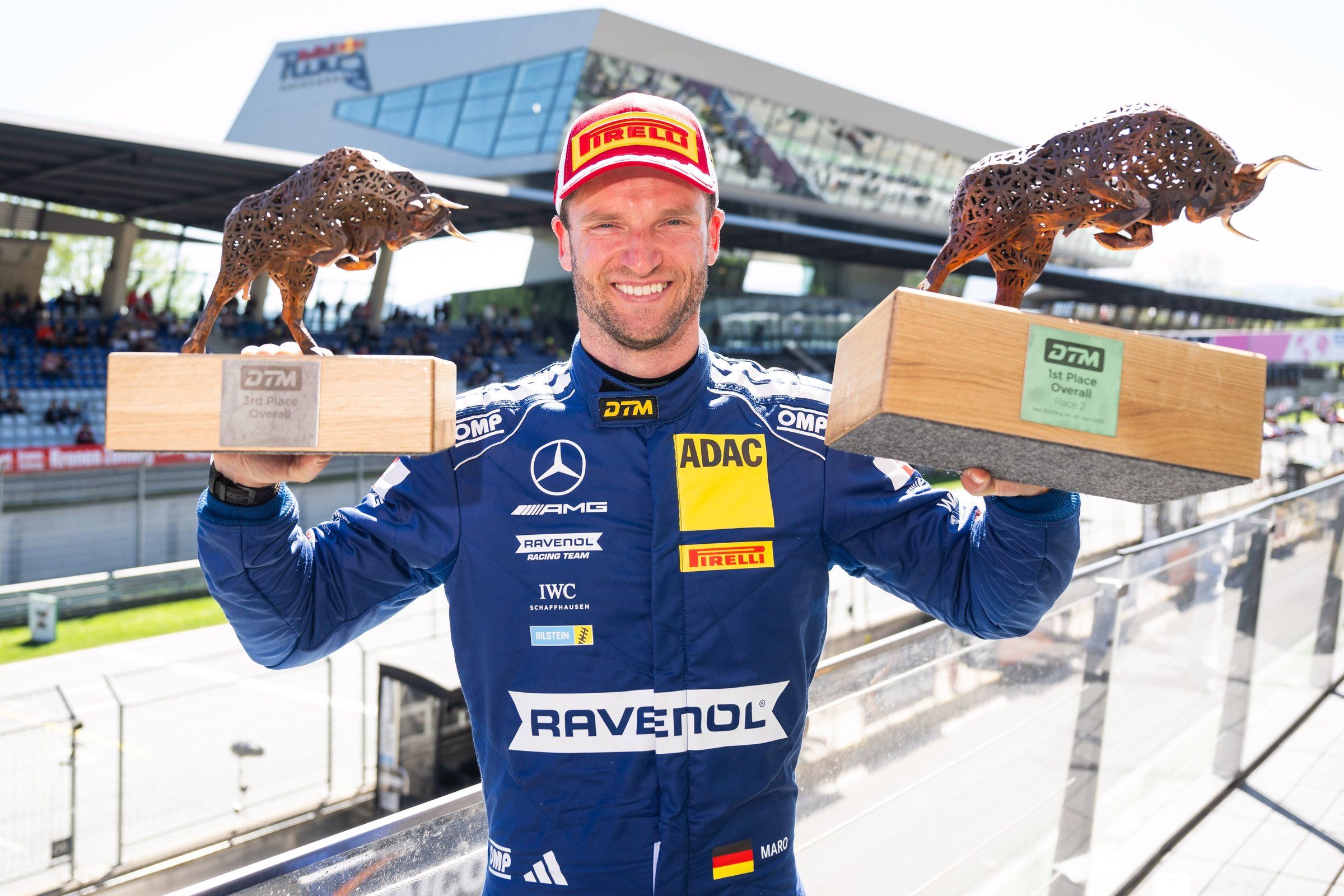 Maro Engel holding two DTM trophies